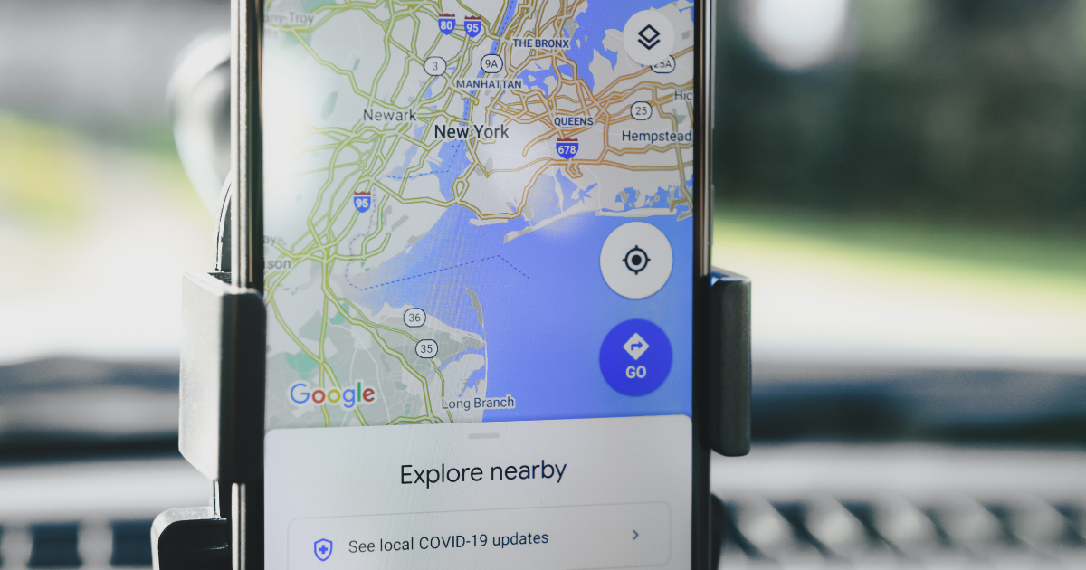Ilustração de um smartphone exibindo um mapa com pins de localização e um site profissional otimizado para SEO local pela VitalPulse.